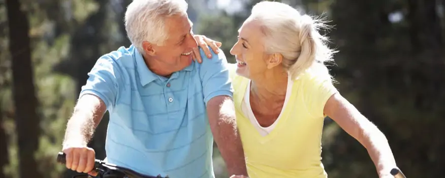 Older couple with white hairs biking