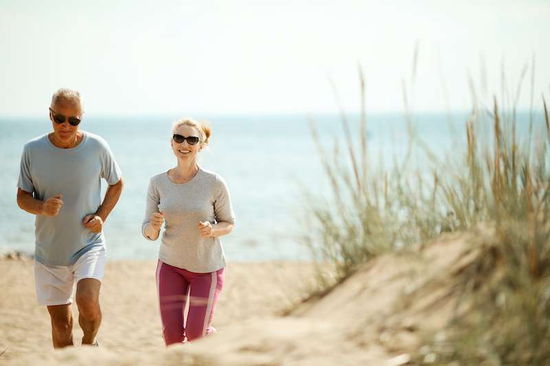 older couple running on the beach