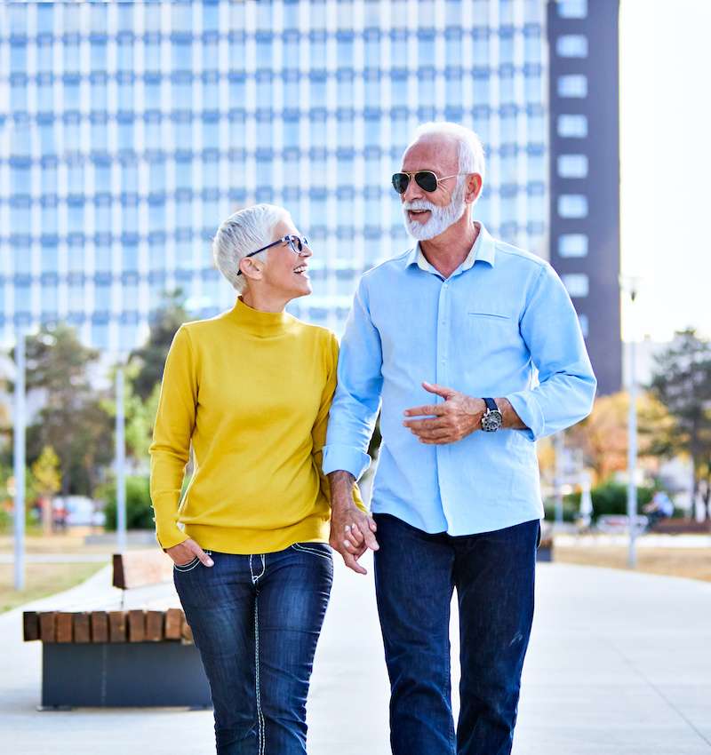 elderly couple walking, holding hands