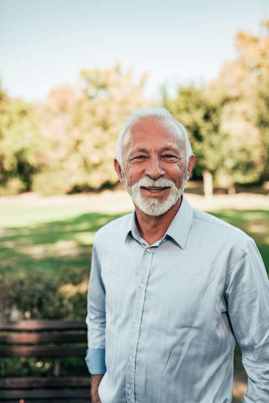 Happy older man standing outside