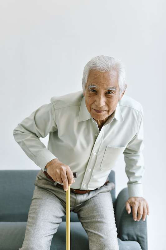 older male using a cane to stand up