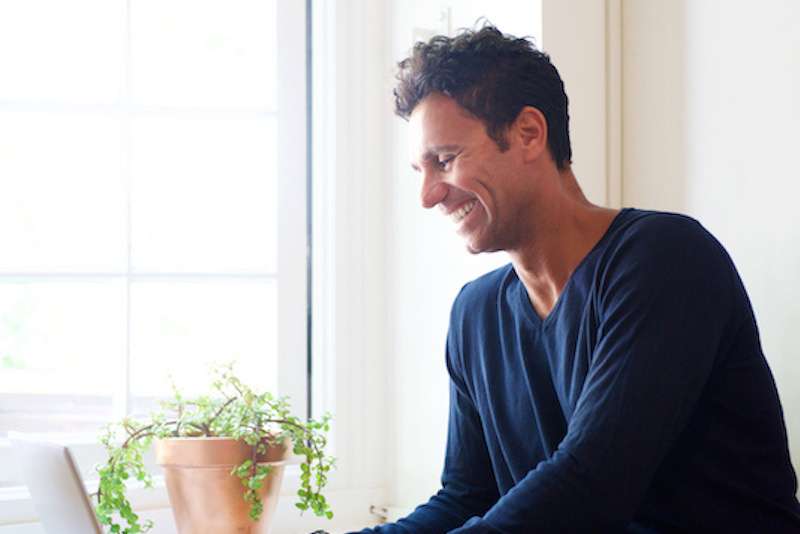 young male sitting down, using a computer