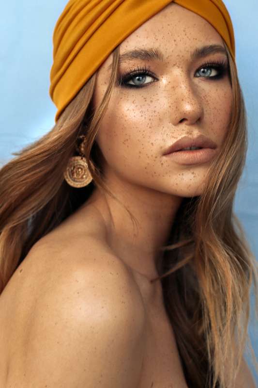 Beautiful young woman with freckles, wearing an orange headband