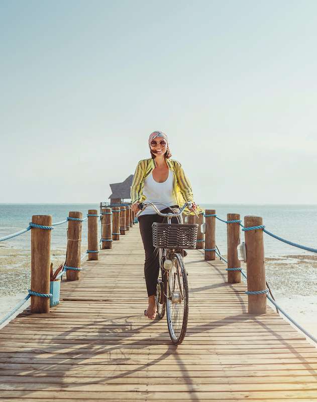 young woman riding a bike down a dock