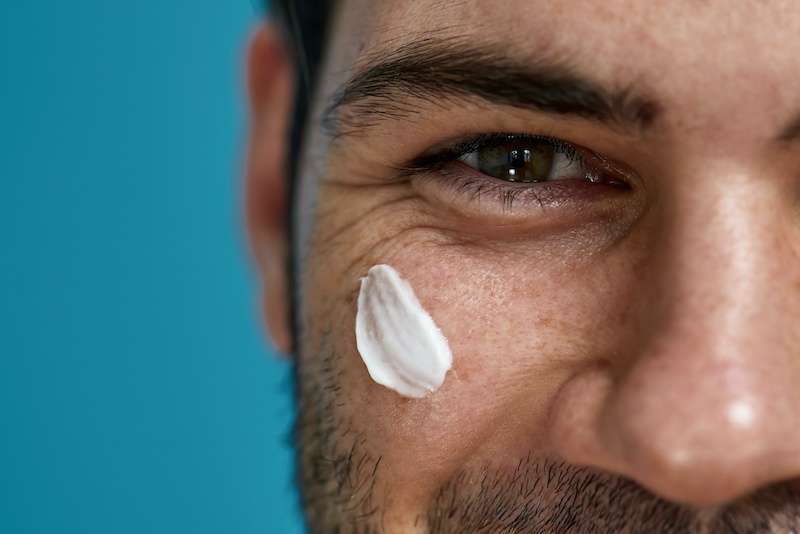 close-up image of man with skincare product on his face