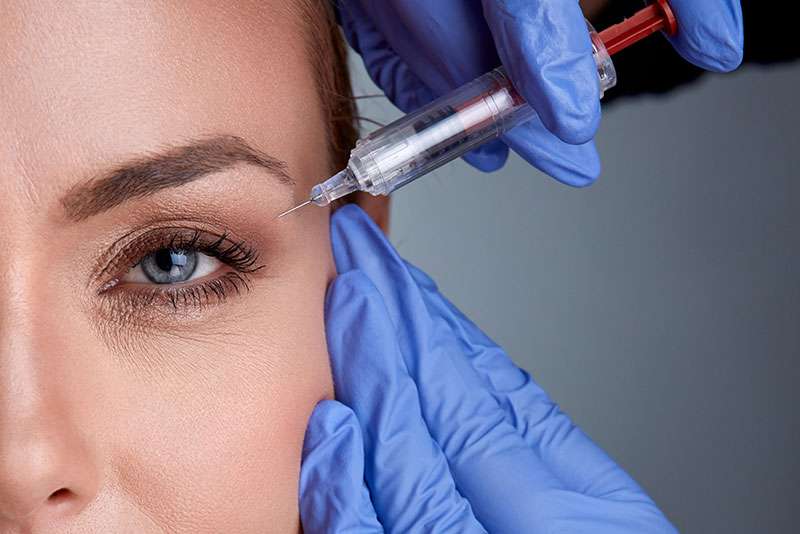 woman receiving Botox injection near eyebrow