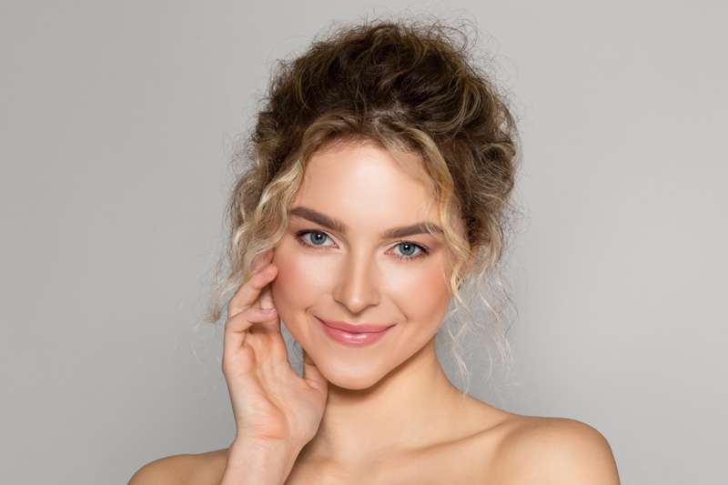 Young woman applying skincare products