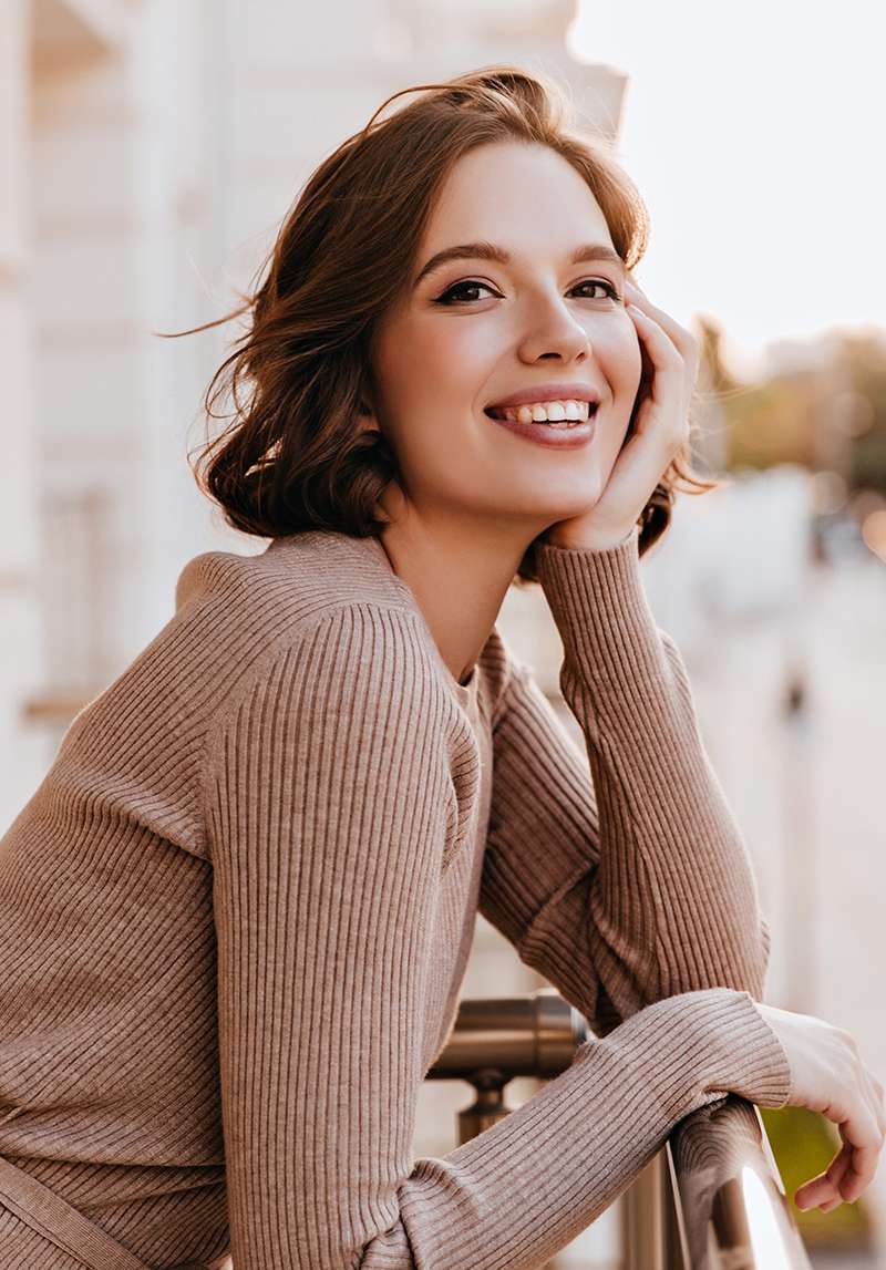 Adorable dark-eyed girl laughing at balcony