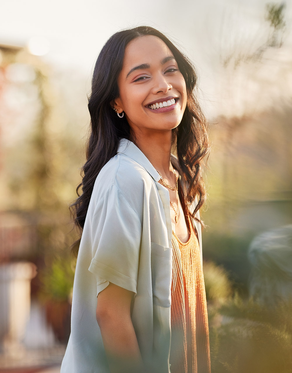 Younger female smiling sitting near a window