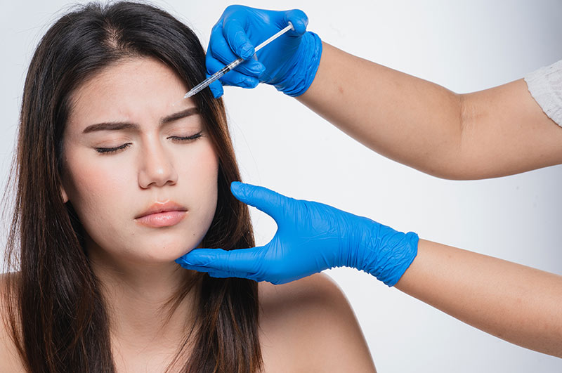 Close-up of a woman getting a forehead injection.