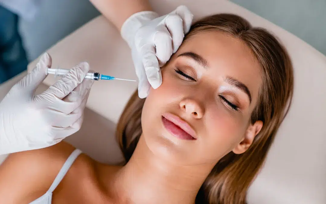 young woman gets beauty facial injections in salon
