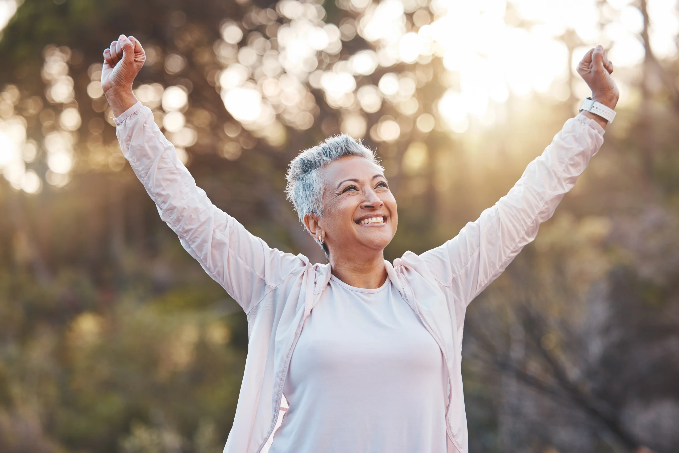 Senior woman, smile and nature while outdoor for freedom, happiness and a healthy lifestyle with fitness and fresh air.